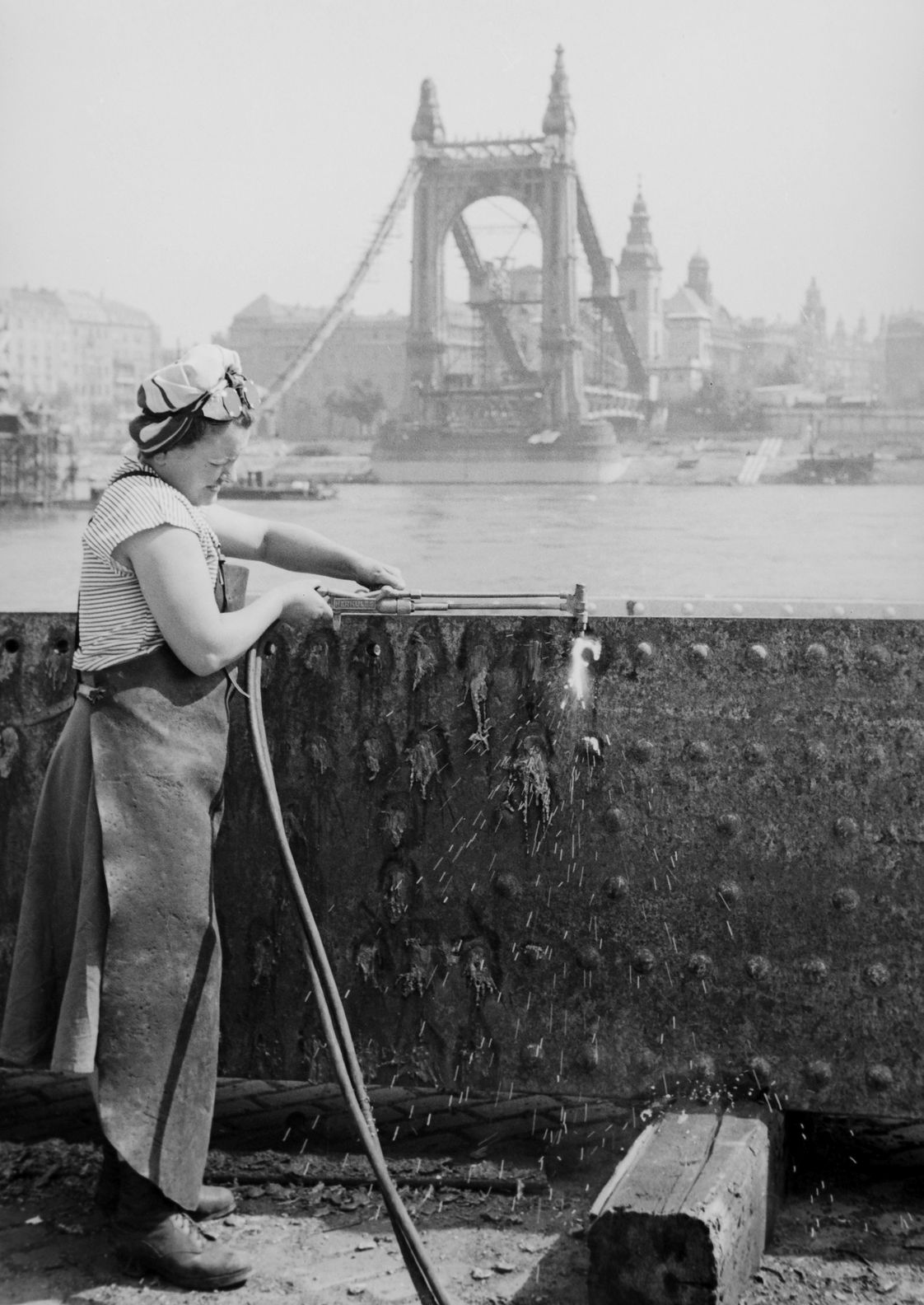 Szakmunkásnő a budai alsó rakparton az Erzsébet híd elemét darabolja, 1949. (Fortepan / Kovács Márton Ernő)